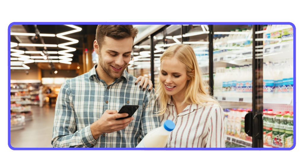 Pareja en supermercado leyendo lista de compras con la app Ibotta