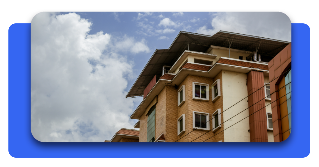 Sección 8: regístrese en la lista de espera para vivienda asequibles 2 Un gran edificio con ventanas simétricas bajo un cielo parcialmente nublado. Vivir cerca de servicios esenciales y centros de salud garantiza calidad de vida.