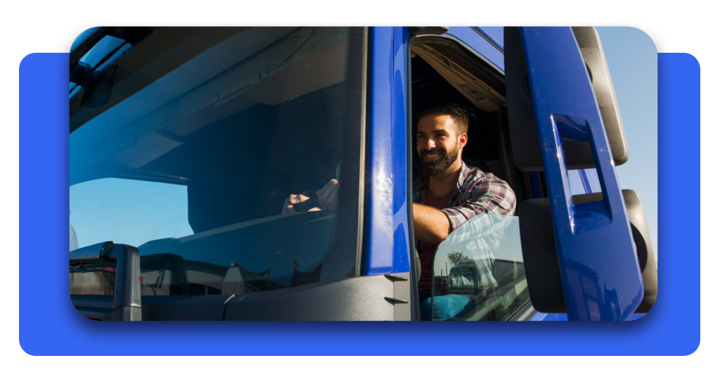 Examen de camión DGT: practica gratis y aprueba más fácil 4 Un camionero sonríe desde su cabina azul. El uso correcto del tacógrafo y respetar los descansos previene los accidentes en la ruta.