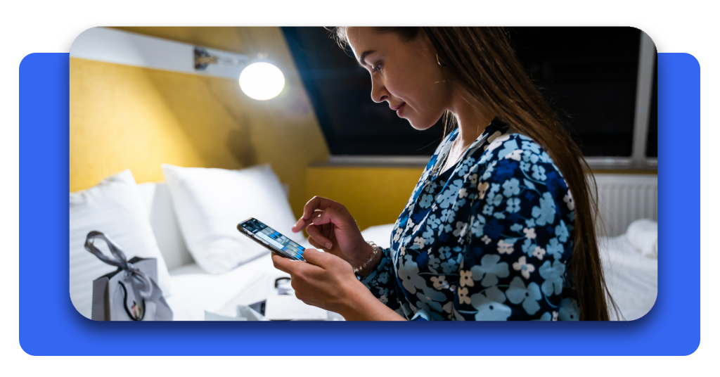 Cómo bajar la factura de luz a la mitad (sin dejar de usar nada) 4 Mujer joven consultando en su teléfono inteligente la aplicación para monitorear el consumo de luz y ahorrar en la factura eléctrica del hogar.