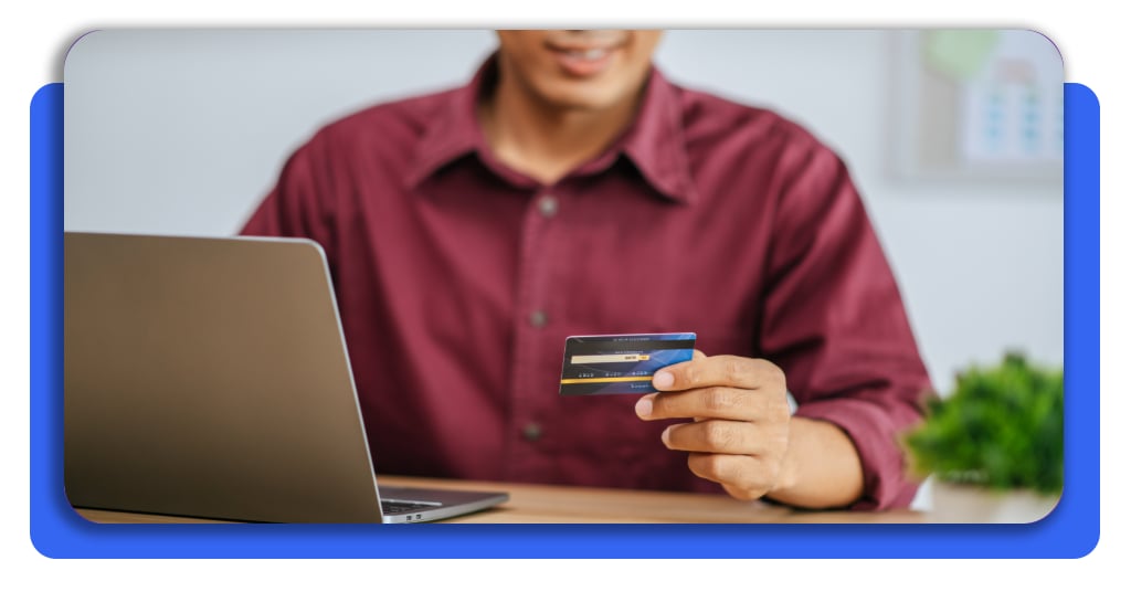 Tarjeta sin verificación severa de crédito (no hard inquiry) 4 Hombre ingresando datos de su tarjeta garantizada en una computadora, un proceso digital que facilita la creación de historial sin afectar el puntaje.